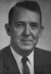 A photographic portrait of a man wearing a suit