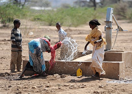 Children play by a newly installed hand pump in the village of Jedane.