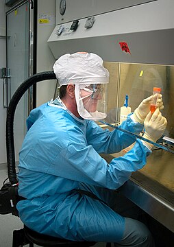 Dr. Terrence Tumpey examining a laboratory-grown reconstruction of the 1918 Spanish flu virus in a biosafety level 3 environment.