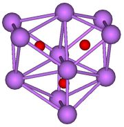 The stick and ball diagram shows three regular octahedra, which are connected to the next one by one surface and the last one shares one surface with the first. All three have one edge in common. All eleven vertices are purple spheres representing caesium, and at the center of each octahedron is a small red sphere representing oxygen.