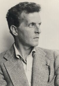 Photo of a man with short hair wearing a suit