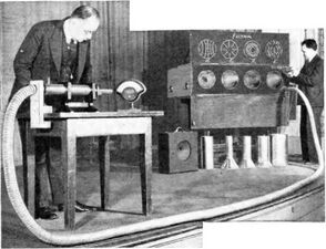 Southworth (at left) demonstrating waveguide at IRE meeting in 1938, showing 1.5 GHz microwaves passing through the 7.5 m flexible metal hose registering on a diode detector
