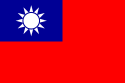 A red flag, with a small blue rectangle in the top left hand corner on which sits a white sun composed of a circle surrounded by 12 rays.