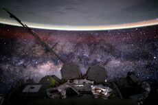 View from International Space Station, showing the yellow-green airglow of Earth's ionosphere with the Milky Way in the background.