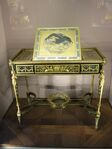Louis XVI style writing table of Marie-Antoinette; by Adam Weisweiler; 1784; oak, ebony and sycamore veneer, Japanese lacquer, steel, bronze gilt; 73.7 x 81. 2 cm; Louvre[59]