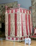 Baroque four-poster bed from the Château d'Effiat; c.1650; natural walnut, chiselled Genoa silk velvet and embroidered silks; 295 cm; Louvre[51]