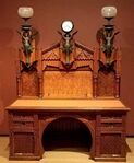 Desk; designed by Frank Furness, made by Daniel Pabst; 1870–1871; walnut, walnut veneer, rosewood (knobs), brass, iron, steel and glass; 196.9 × 157.5 × 81.9 cm; Philadelphia Museum of Art (Philadelphia, USA)[63]