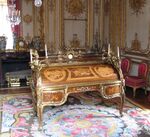 Bureau du Roi (Rococo); by Jean-François Oeben and Jean Henri Riesener; 1760–1769; bronze, marquetry of a variety of fine woods and Sèvres porcelain; 147.3 x 192.5 x 105; Palace of Versailles (Versailles, France)[57]