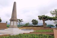 A photograph taken in 2014 of a large memorial within a school surrounded by trees.