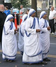 Four nuns in sandals and white-and-blue saris