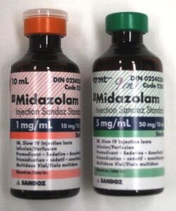 Two 10 mL bottles labeled Midazolam. The bottle on the left has a label in red and says 1 mg/mL; the one on the right is in green and says 5 mg/mL. Both bottles have much fine print.