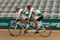 Australian Paralympic athletes using a two-seated tandem racing bicycle; the visually impaired cyclist pedals in rear, while a sighted "pilot" sits in the front.