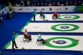 Wheelchair curling uses a specially adapted long stick to launch the "rock" down the ice. These players are delivering rocks in the 2010 Vancouver Paralympics.