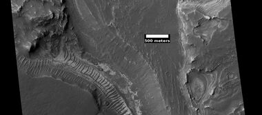 Layers on floor of Noctus Labyrinthus, as seen by HiRISE under HiWish program. Layers probably contain a variety of minerals that were formed with groundwater.