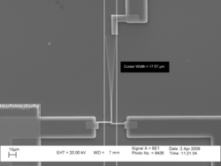A photomicrograph of a vibrating cantilever. Cursors on the picture indicate that the peak-to-peak amplitude of the vibration is 17.57μm.