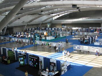 Entrance of a convention center room with meeting attendees preparing to enter.