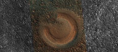 Close view of mud volcano, as seen by HiRISE. Picture is about 1 km across. This mud volcano has a different color than the surroundings because it consists of material brought up from depth. These structures may be useful to explore for remains of past life since they contain samples that would have been protected from the strong radiation at the surface.