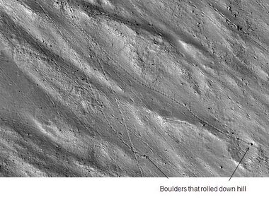 Enlargement of cliff in Kasei Valles system in previous image showing boulders and their tracks, as seen by HiRISE. Click on image to see a boulder only 2.2 yards across (smaller than a bedroom).