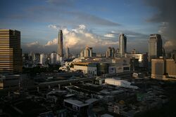 Many low-rise buildings in the foreground, with an elevated rail line and several medium box-saped buildings beyond; many tall buildings in the background