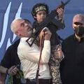 Hamas leader Yahya Sinwar hoisting a gun-toting child, the son of a 'martyred' Hamas fighter, in front of a large crowd 2021.jpg