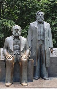 Photo of a statue of two men, one sitting and the other standing