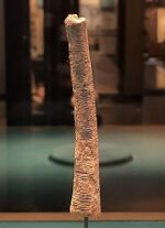 Photograph of an ancient bone with numerous lines etched into it.