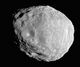An irregular body, whose outline looks like an approximate circle in this image. It is illuminated from the bottom-left. The terminator runs from the top-left to bottom-right. The surface is covered by craters.