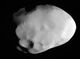 An oblong object with a few large craters and a smooth surface