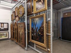 In museums, paintings, framed and unframed, are normally hung on sliding or fixed racking.