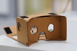 A Google Cardboard headset, photographed on a table in shallow depth of field.