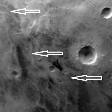 Ridges, believed to be eskers of the Dorsa Argentea Formation, as seen by Mars Global Surveyor wide angle MOC. White arrows point to the ridges.