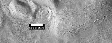 Dipping layers and layers of mantle, as seen by HiRISE under HiWish program. The dipping layers look similar to layers of mantle.
