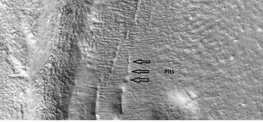 Close-up that shows cracks containing pits on the floor of a crater, as seen by HiRISE under HiWish program. Cracks may start as a line of pits that enlarge, then join.