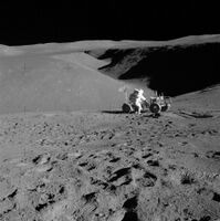 Lunar landscape with man leaning over rover