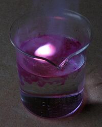 Potassium reacting with water, producing heat, hydrogen gas, and a lilac flame.