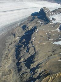 Dark rough rock explosed near a glacier.