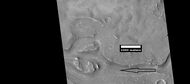 Close view of streamlined shapes, as seen by HiRISE under HiWish program Arrow indicates the direction of past flowing water.
