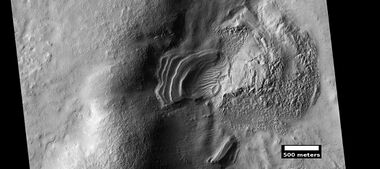 Layered feature that is probably the remains of a once widespread unit that fell from the sky, as seen by HiRISE under the HiWish program. Dipping layers are common in some regions of Mars. They may be the remains of mantle layers. Another idea for their origin was presented at 55th LPSC (2024) by an international team of researchers. They suggest that the layers are from past ice sheets.[66]