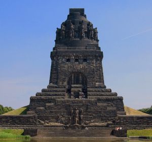 monument commemorating the battle, tall square block, soldier on top, images of soldiers around the monument