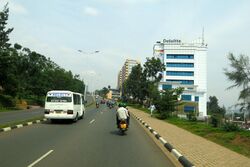 Photograph of a street, including buildings, vehicles and pedestrians