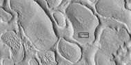 Close view of terrain caused by ice leaving the ground, as seen by HiRISE under HiWish program Box shows size of football field.