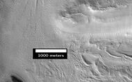 Smooth cliff of Mamers Valles. Note the lack of boulders. Much of the surface may have just been blown in or dropped from the sky (as dirty frost). Image from HiRISE.