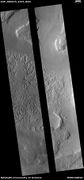 Wide view of terrain with hollows. The hollows were created when ice left the ground. The black strip is due to a malfunction.