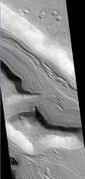 Clanis and Hypsas Valles, as seen by HiRISE. Ridges are probably due to glacial flow. So water ice is under a thin layer of rocks.