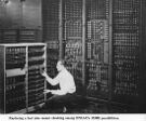 Man replacing one vacuum tube out of hundreds in early computer