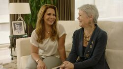 Two smiling women sitting together on a sofa